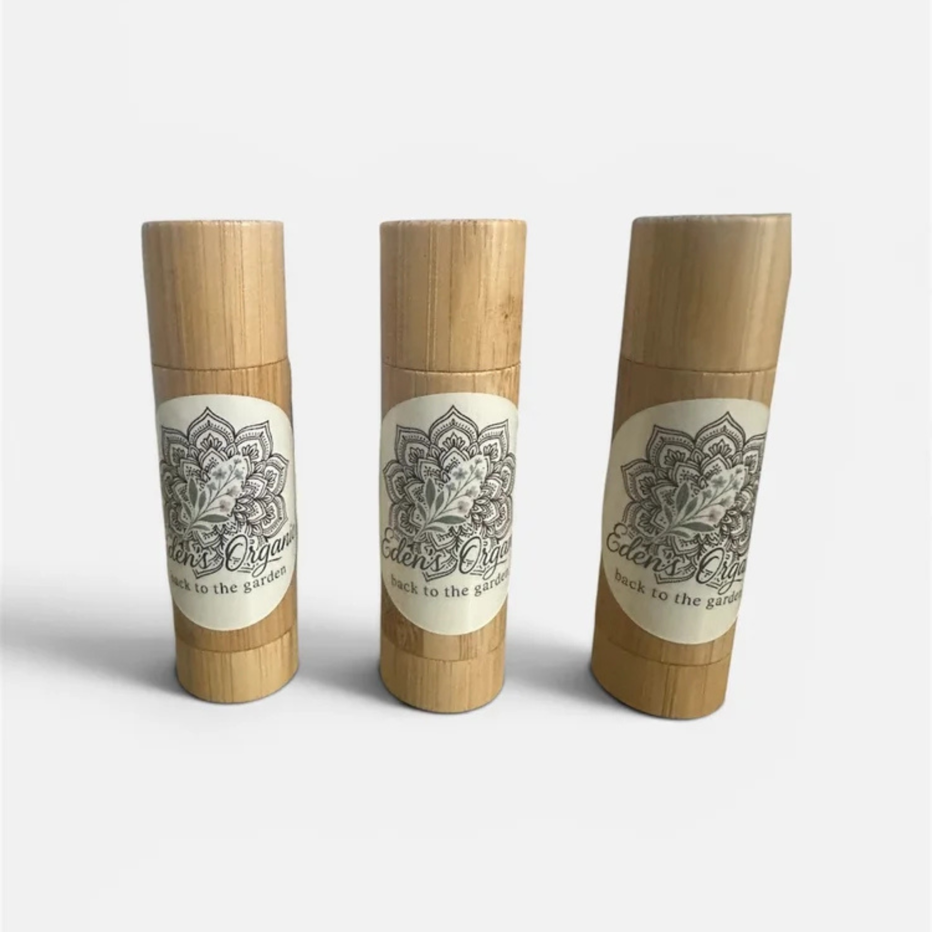 Three bamboo containers with decorative labels on a white background