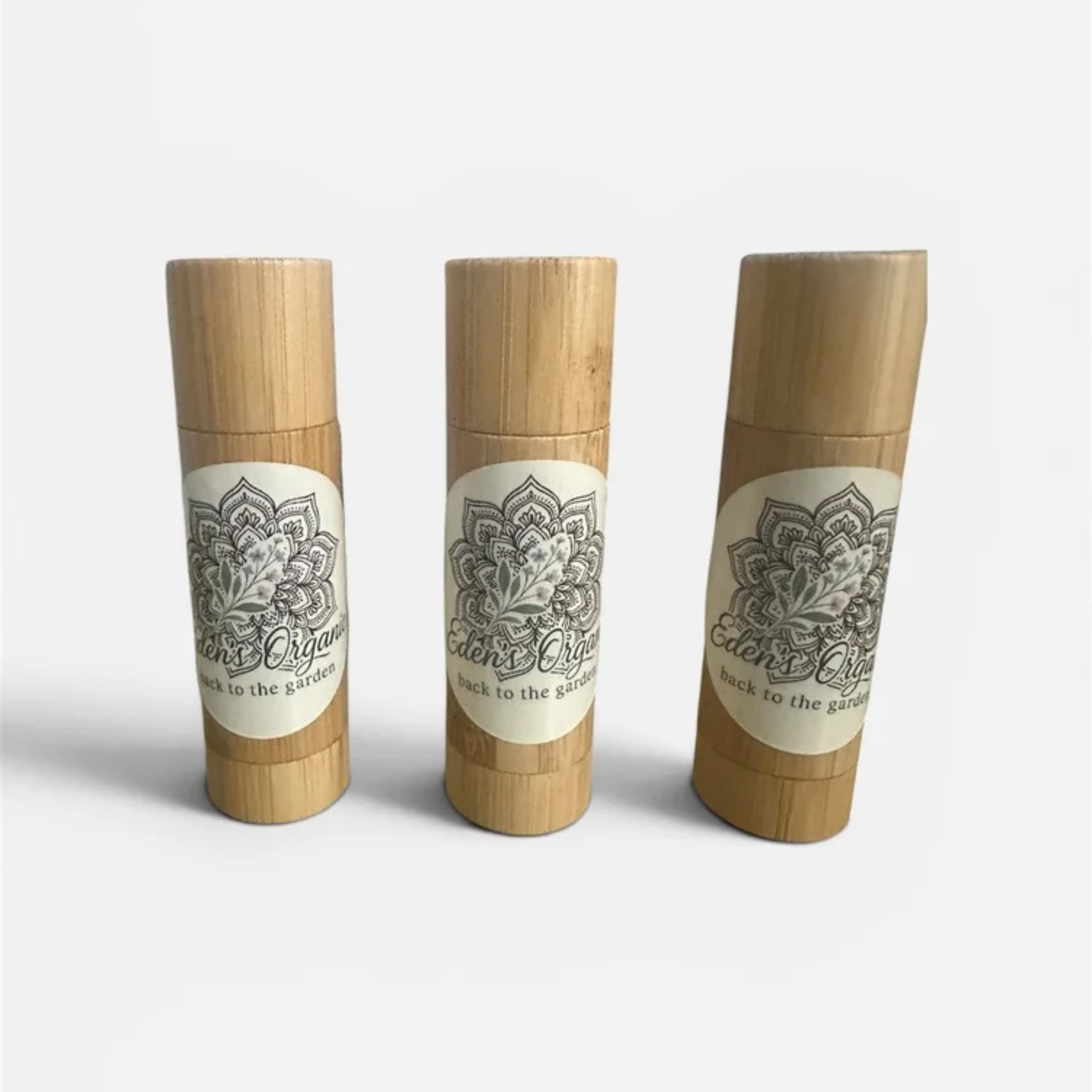 Three bamboo containers with decorative labels on a white background